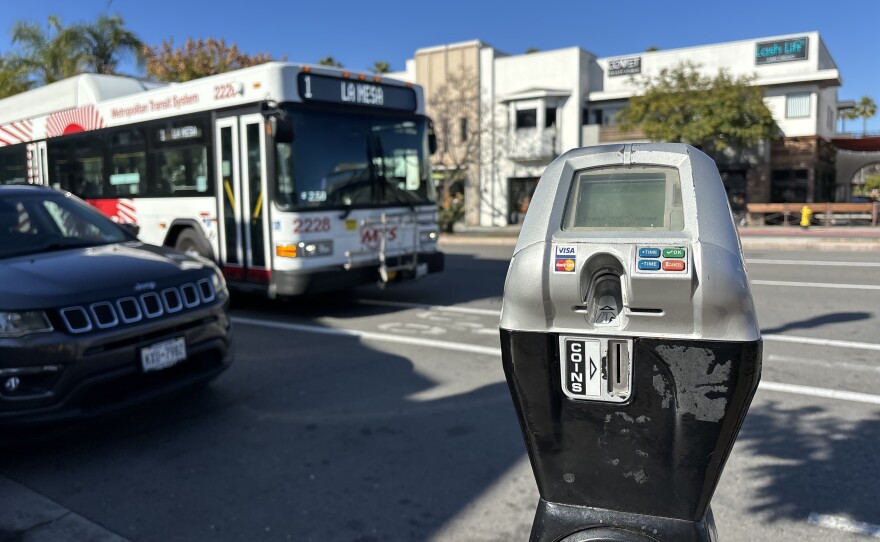 An MTS bus passes by a parking meter on University Avenue in Hillcrest, Dec. 12, 2023.