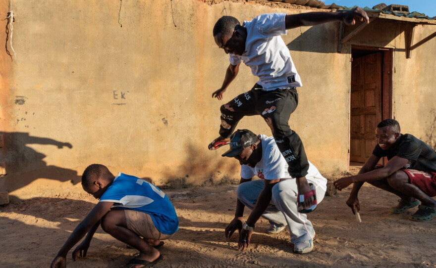 Pastor Billiance Chondwe and the boys play outside their home. Pastor Billy is trying to help 25 newly orphaned children in his community. He regularly visits Joseph, Gift and Alumbwe, who lost their parents to HIV this year.