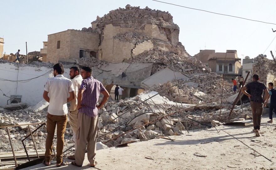 People inspect the remains of a destroyed mosque in Mosul on July 27.