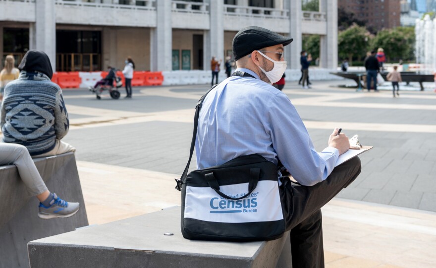 A U.S. census worker sits in the plaza of the Lincoln Center for the Performing Arts in New York City in September. The Census Bureau announced Wednesday that the first results of the 2020 census are expected to be released by April 30.