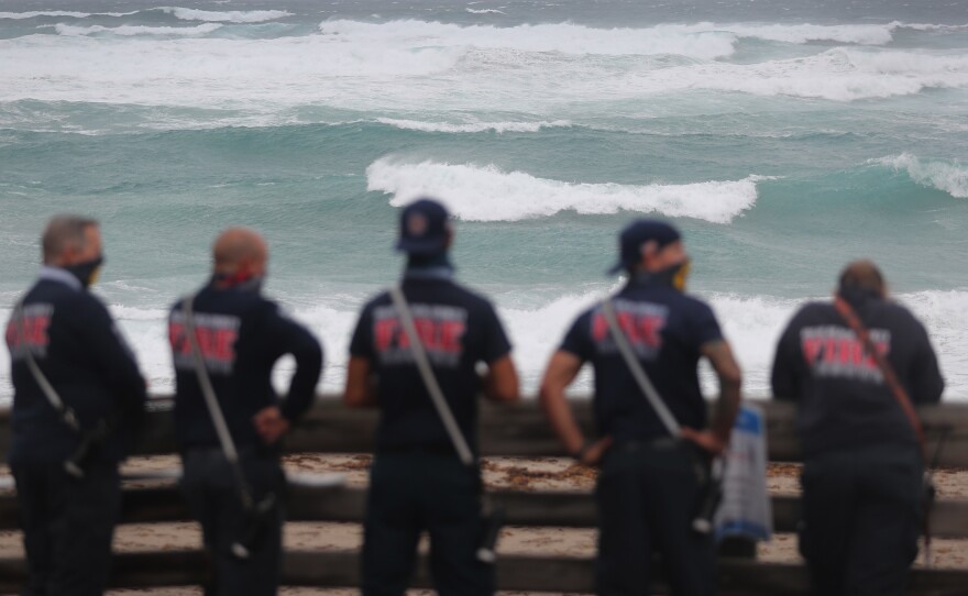 Palm Beach County Fire Rescue check out the ocean as waves crash ashore from Tropical Storm Isaias as it passes through the area on August 2, 2020 in Juno Beach, Fla.