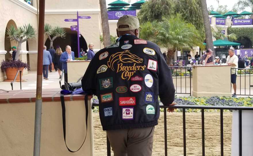 A Breeders' Cup attendee wearing a Breeders' Cup jacket with several horse racing patches on it at the Del Mar Racetrack on November 5, 2021.