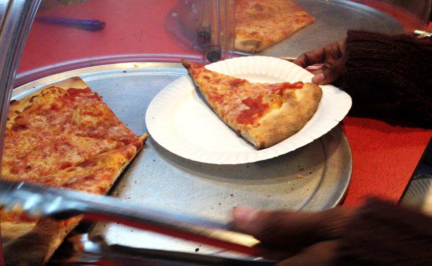 Slices of pizza on the counter of Rosa's Fresh Pizza where customers are encouraged to pay it forward.
