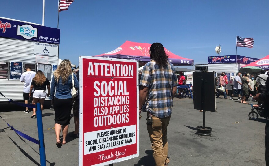 A sign outside the entrance of Kobey's Swap Meet at the Sports Arena encourages guests to social distance due to the COVID-19 pandemic. April 10, 2021.