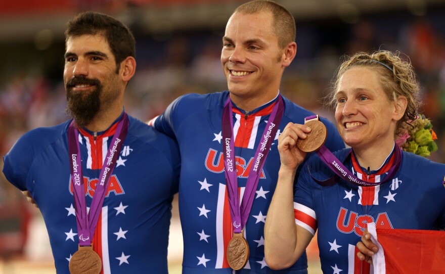 Bronze medalists Jennifer Schuble (right), Sam Kavanagh (center) and Joseph Berenyi of the United States stand on the podium for the Mixed C1 to 5 cycling team sprint finals at the 2012 Paralympic Games in London.