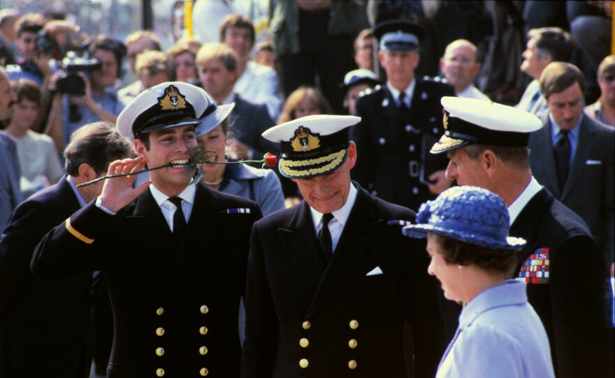 Prince Andrew holds a rose in his mouth, as he and his mother and father, Queen Elizabeth and Prince Philip (right) return from the Falklands on board the HMS Invincible. Princess Anne is behind Prince Andrew. (undated)