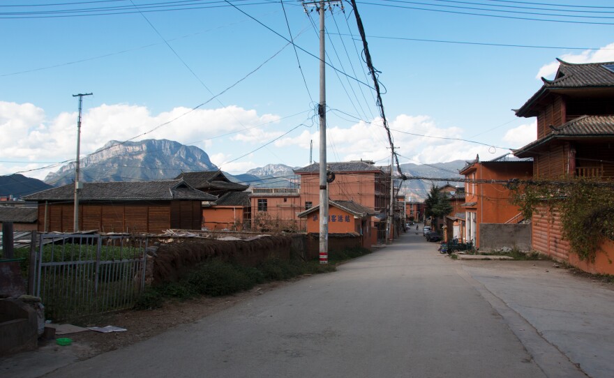 A street leads through Luoshui Village towards Lugu Lake.