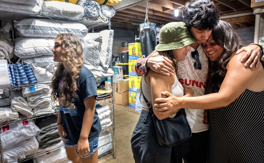 Zoë Miller, Max Louis and Haley Miller share a hug. Louis came from Oahu to help those who lost their homes in the wildfires.