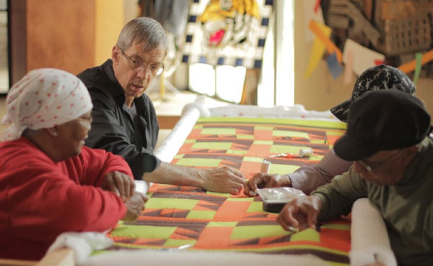 Quiltmaker Joe Cunningham at the frame with Gee’s Bend quilters Ritamae Pettway, Lucy Mingo and Revil Mosely.