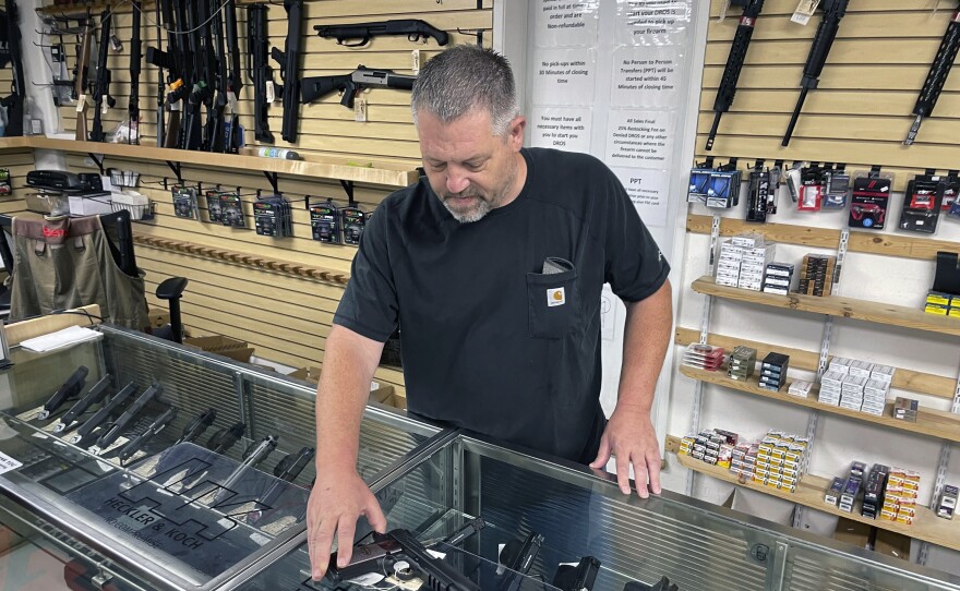 File photo of John Parkin, co-owner of Coyote Point Armory displaying a handgun at his store in Burlingame, Calif., June 23, 2022.