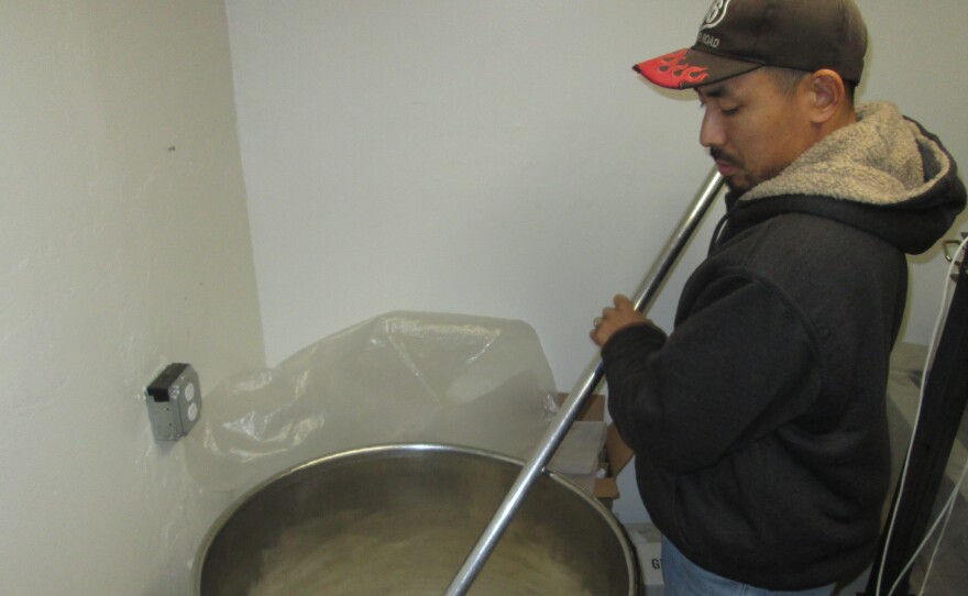 Atsuo Sakurai stirs a fresh batch of Arizona Sake at his home brewery.