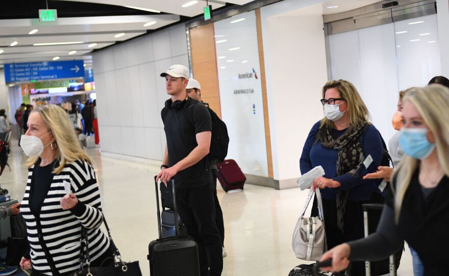 Airline passengers, some not wearing face masks following the end of Covid-19 public transportation masking rules, wait to board a SkyWest Airlines flight at Los Angeles International Airport on April 19, 2022.