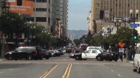 San Diego police cruisers block streets off in the East Village after a man with a gun is reported being seen in a building on Broadway.
