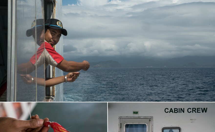 Hendi Wahyu, 33, is a member of the boat's crew. His job is parking the trucks when the ferry is in port. Between stops, he fishes off the side.