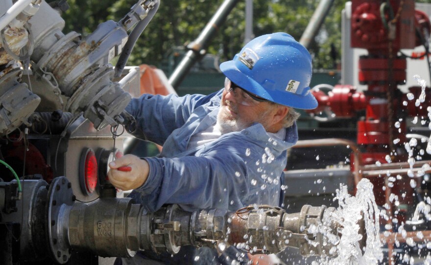 A local contractor closes the valve on his tanker truck on July 27, 2011, after watering the roads to help keep down dust at a hydraulic fracturing operation in Claysville, Pa.