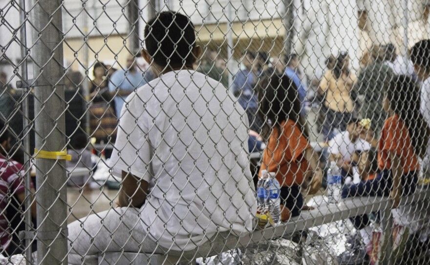 Migrants taken into custody related to cases of illegal entry into the United States sit in a facility in McAllen, Texas, in June 2018. On Tuesday, a federal judge ruled that asylum-seeking migrants can't be denied bond and held indefinitely.