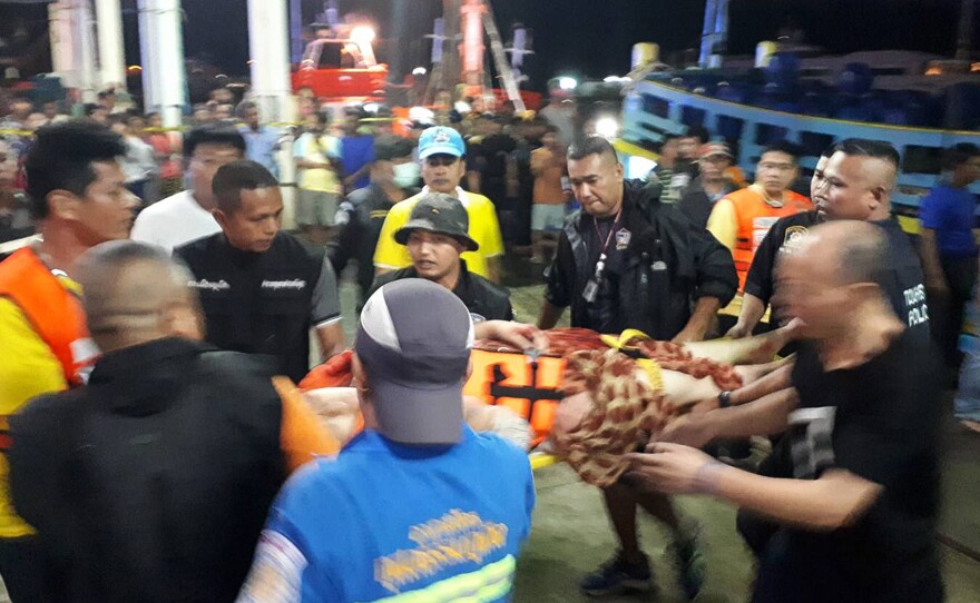 Thai rescue crews attend to passengers of a capsized tourist boat in rough seas at a port in Phuket on Thursday.