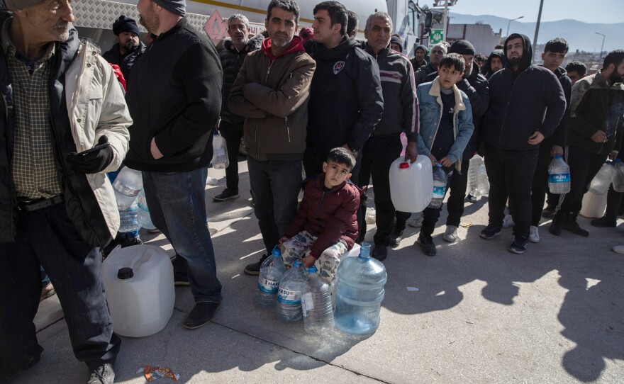 People wait in line for clean water in Hatay, Turkey on Thursday.