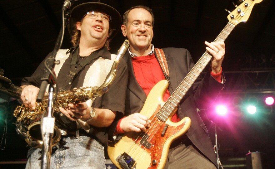 Huckabee (right) plays bass guitar with a member of the Boogiewoogers band at a rally in Iowa in 2008.