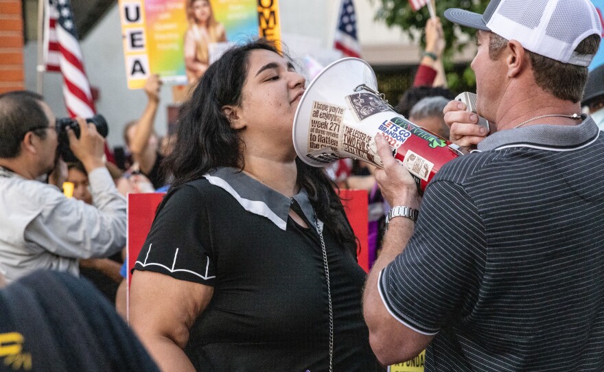 Henson speaks into a bullhorn that is directly in the face of a pro LGBTQ+ demonstrator at a rally in Orange, Ca., Sept. 7, 2023.