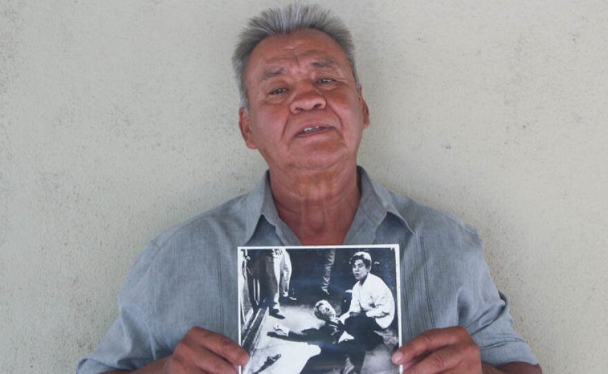 Juan Romero earlier this year at his home in Modesto, Calif., holding a photo of himself and Sen. Robert F. Kennedy, taken by The Los Angeles Times' Boris Yaro on June 5, 1968. Romero died this week at age 68.