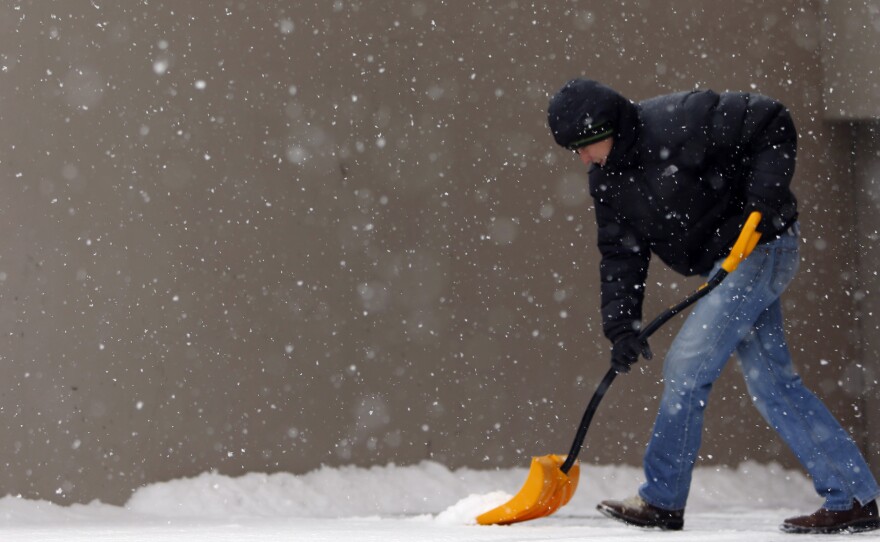 In Denver, Cole Baldock shovels snow on Wednesday morning.