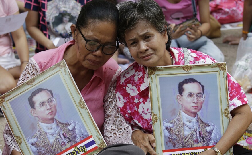 Two women cry as they pray for Thailand's King Bhumibol Adulyadej outside Siriraj Hospital in Bangkok on Thursday. The king's death was announced shortly afterward. The world's longest reigning monarch, the king was on the throne for 70 years.