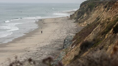 People walk along the bluffs in Del Mar on July 25, 2023.