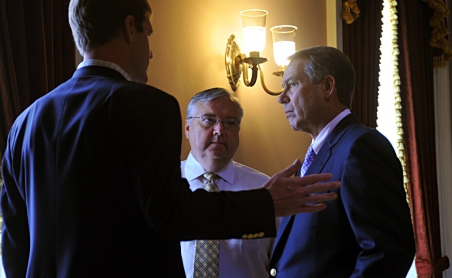 House Speaker John Boehner (right) consults with staff members before entering the House chamber on Saturday.