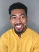 Man smiling wearing a yellow shirt