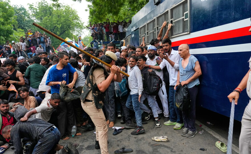 Police use long sticks to disperse supporters of the Cockroach Janta Party as they attempt to march toward India's Parliament, demanding the resignation of the education minister, in New Delhi, Monday.
