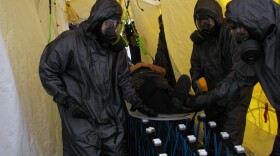 Crews from Escondido and Heartland Fire decontaminate a "victim" from a mock chemical spill in a temporary unit in the Qualcomm Stadium parking lot. 