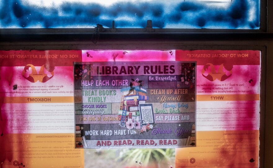The "Library Rules" are stuck to a painted window in the Hot-Spot Library. Kids who borrow books must submit a book review when they return them.