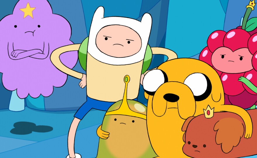 Finn is in the middle, with the skinny arms. Jake is the dog. Together, they have <em>Adventure Time</em>.
