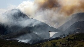 A Sikorsky S-64 Aircrane firefighting helicopter drops water on a hotspot burning close to some homes near Horsetooth Reservoir on Monday June 11, 2012 near Laporte, Colorado. 