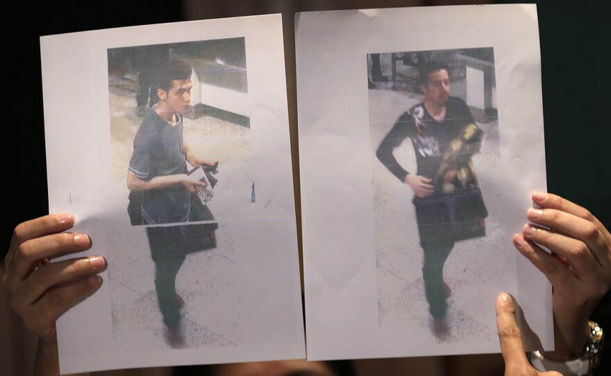 At a news conference Tuesday in Sepang, Malaysia, authorities held up pictures of the two Iranian men who are said to have boarded Malaysia Airlines Flight 370 with stolen passports. The man at left is said to 19-year old Pouria Nour Mohammad Mehrdad. The other man was not identified. Authorities believe the men were trying to emigrate to Europe.