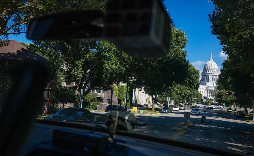 The state Capitol building is seen through the windows of police officer Nicole Schmitgen's squad car during her patrol on Monday, July 18, 2022 in Madison, Wis.
