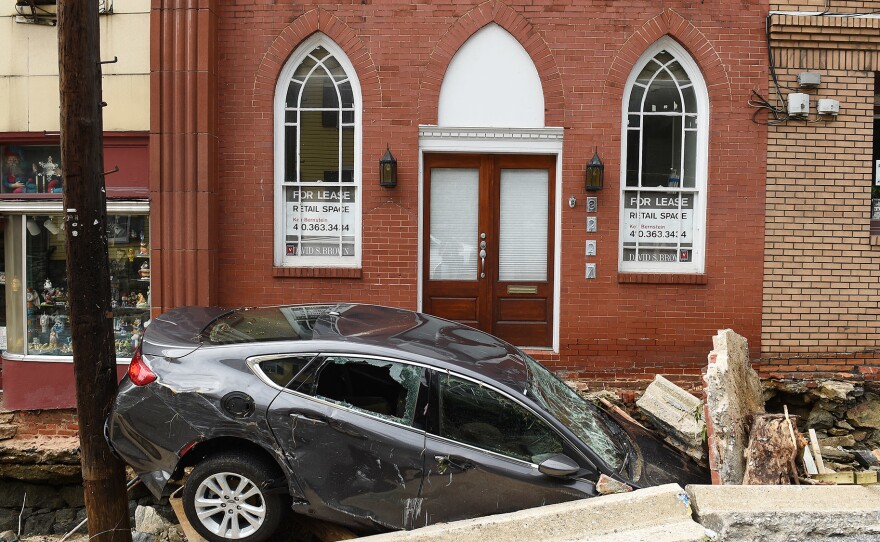 Flooding along Main Street in Ellicott City upended cars, destroyed buildings and killed at least two people. Here, a car sits crushed under the rubble of a sidewalk downtown.