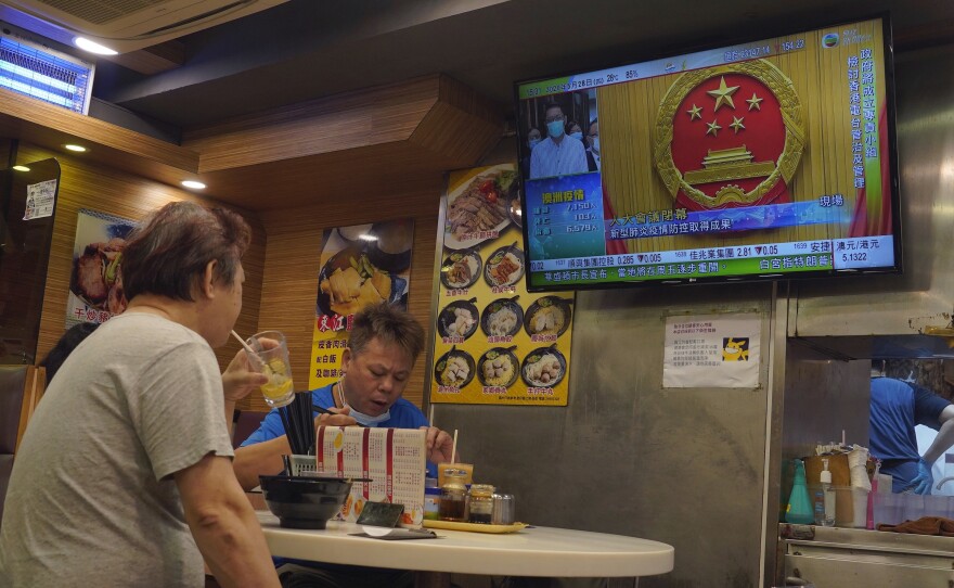 The closing session of China's National People's Congress plays on a television in a Hong Kong restaurant Thursday.