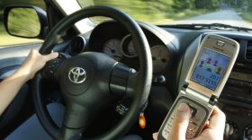 A driver uses a cell phone in Freeport, Maine, in September. Maine and more than a dozen other states have implemented laws to curb distracted-driving practices such as texting or talking on cell phones while operating a car.