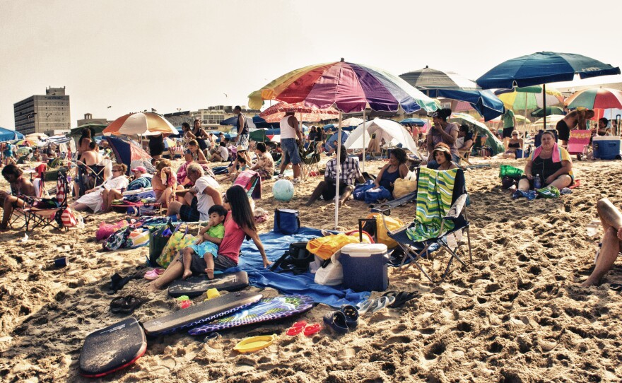 Lazy day summer beach goers relax on the sands of Rehoboth Beach in Delaware.