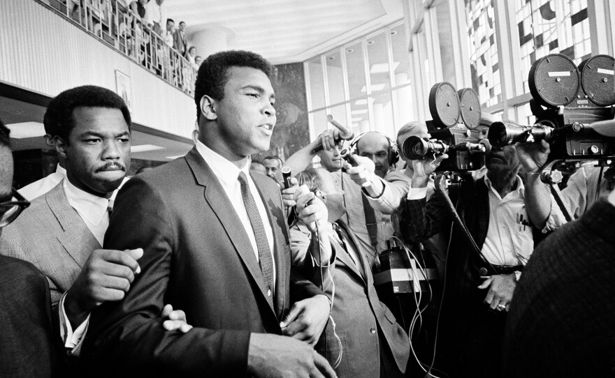 Ali says "no comment," confronted by members of the press as he leaves court for the noon recess, June 19, 1967. Ali was on trial for refusing to be inducted into the armed services.