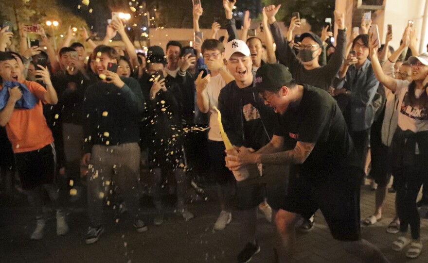 Pro-democracy supporters celebrate after pro-Beijing politician Junius Ho lost his election in Hong Kong, early Monday, Nov. 25, 2019.