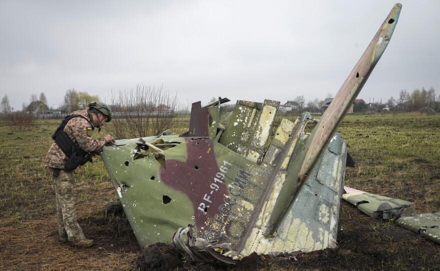 A Ukrainian soldier examines a fragment of a Russian Air Force Su-25 jet after a battle at the village of Kolonshchyna, Ukraine, on April 21. Russia was expected to establish air superiority in the first days of the war. But Ukraine's air defenses have been so effective that Russian pilots often fire their weapons while over Russia and never enter Ukrainian airspace.