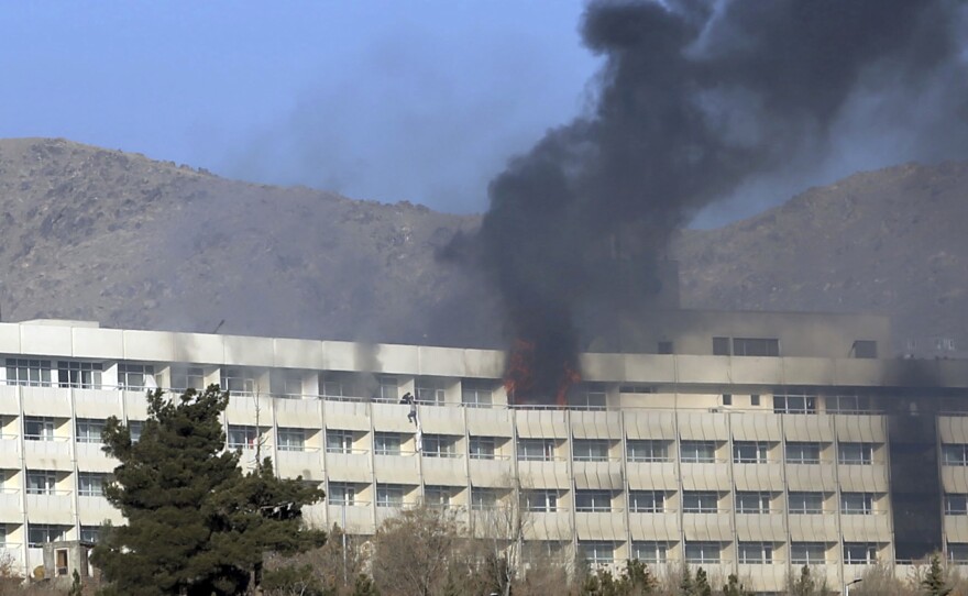 Men try to escape from a balcony of the Intercontinental Hotel on Sunday after an attack in Kabul, Afghanistan.