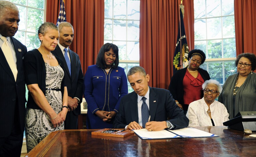 The Congressional Gold Medal has been posthumously awarded to four girls killed in the 1963 bombing of Birmingham's 16th Street Baptist Church. President Obama signed the legislation Friday, as (from left) Birmingham Mayor William Bell, Dr. Sharon Malone Holder, Attorney General Eric Holder, Rep. Terri Sewell, and relatives of Denise McNair and Carole Robertson look on.