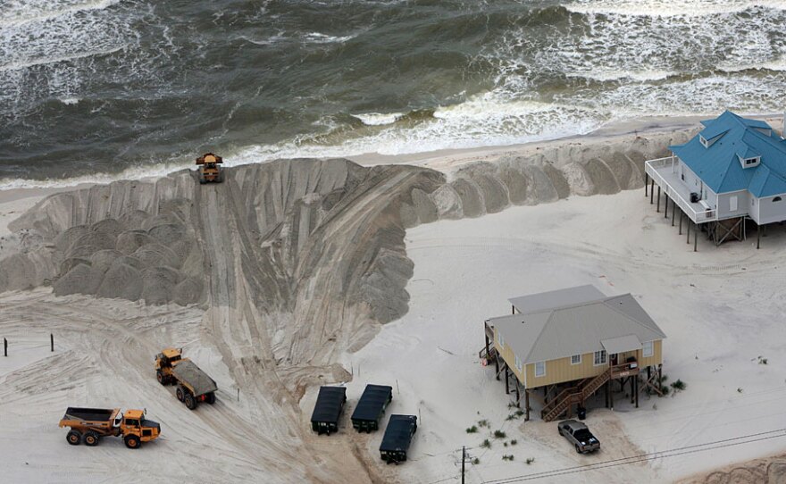 Workers build a sand berm around the homes on the beach on Dauphin Island, Ala., on June 5. More berms are about to be built in the Gulf just off the Louisiana coast. But some scientists question whether the berms will work in keeping oil off the shore -- and whether they'll survive hurricane season.