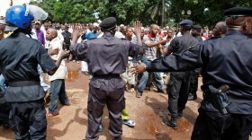 Police control the crowd as they react before looking for the bodies of family members and friends that were killed during a rally.