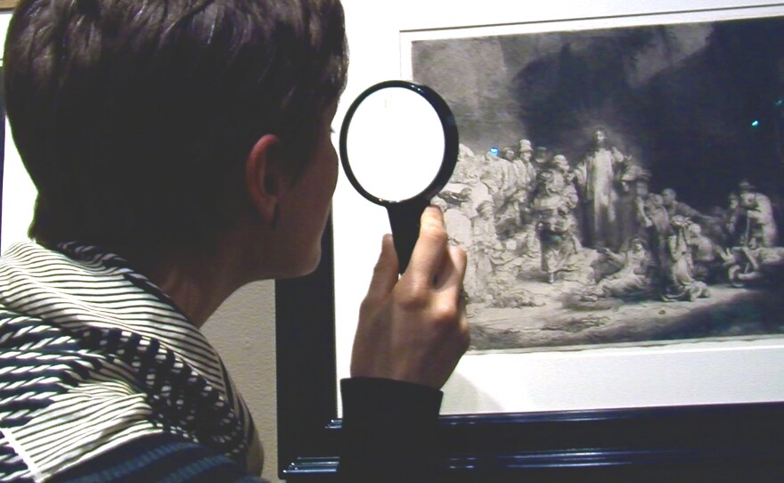 Erin Sullivan Maynes encourages visitors to the "Rembrandt: A Decade of Brilliance" exhibit to take a magnifying glass and get up close to the work.
