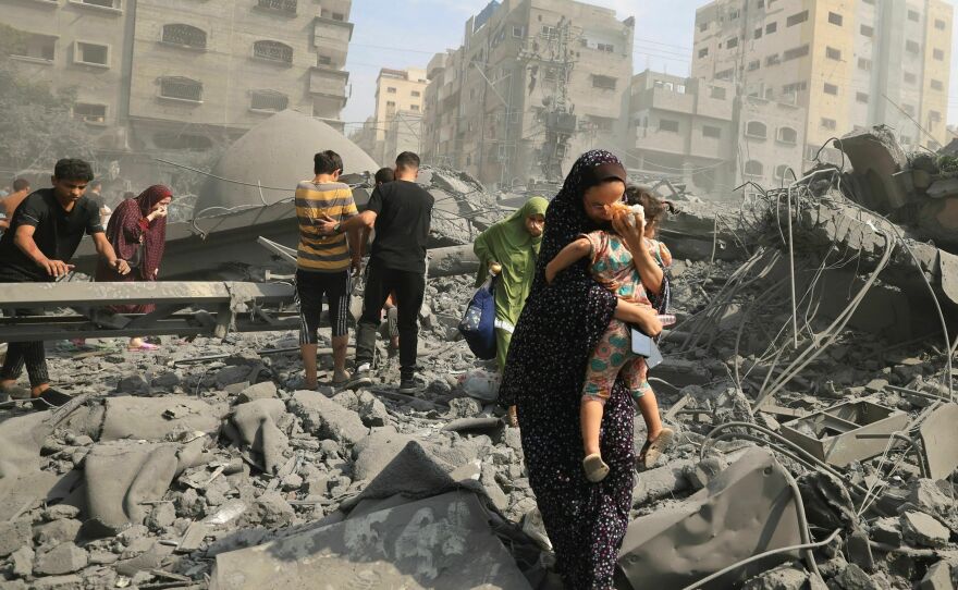 Palestinians evacuate the area following an Israeli airstrike on the Sousi mosque in Gaza City on Oct. 9.